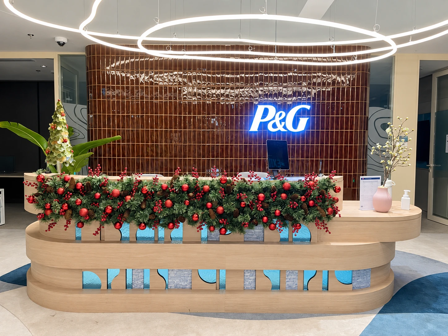 Christmas greenery and red ornaments on a corporate reception desk