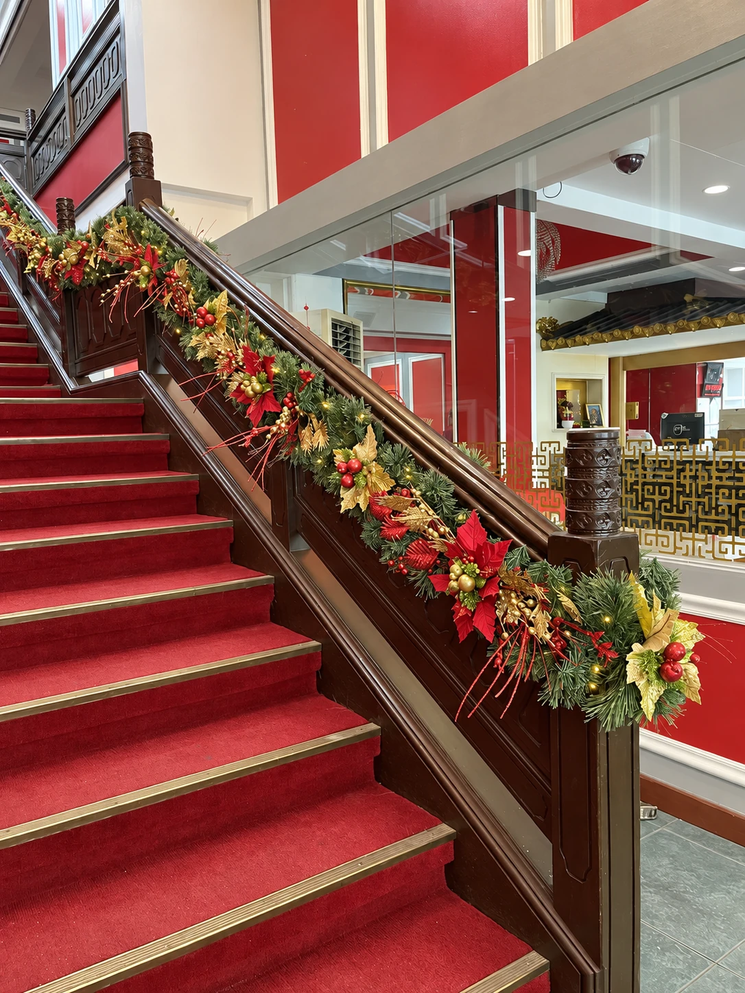 Red and gold Christmas garland installed on a restaurant staircase
